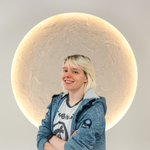 Picture of Samantha Cobden, Head Of Digital PR at Search Theory. She has short blonde hair and is wearing a denim jacket. In the picture, Samantha is smiling and crossing her arms.