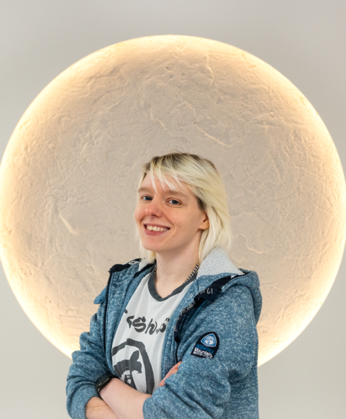 Picture of Samantha Cobden, Head Of Digital PR at Search Theory. She has short blonde hair and is wearing a denim jacket. In the picture, Samantha is smiling and crossing her arms.