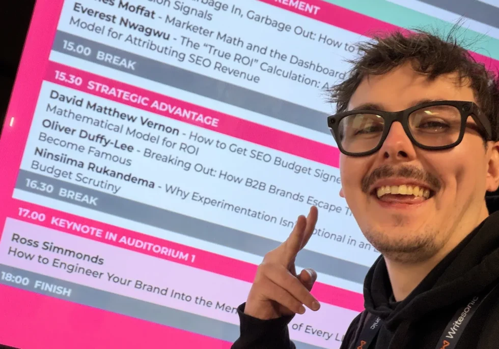 David Matthew Vernon pointing at his name on the MeasureFest schedule at brightonSEO, October 2026