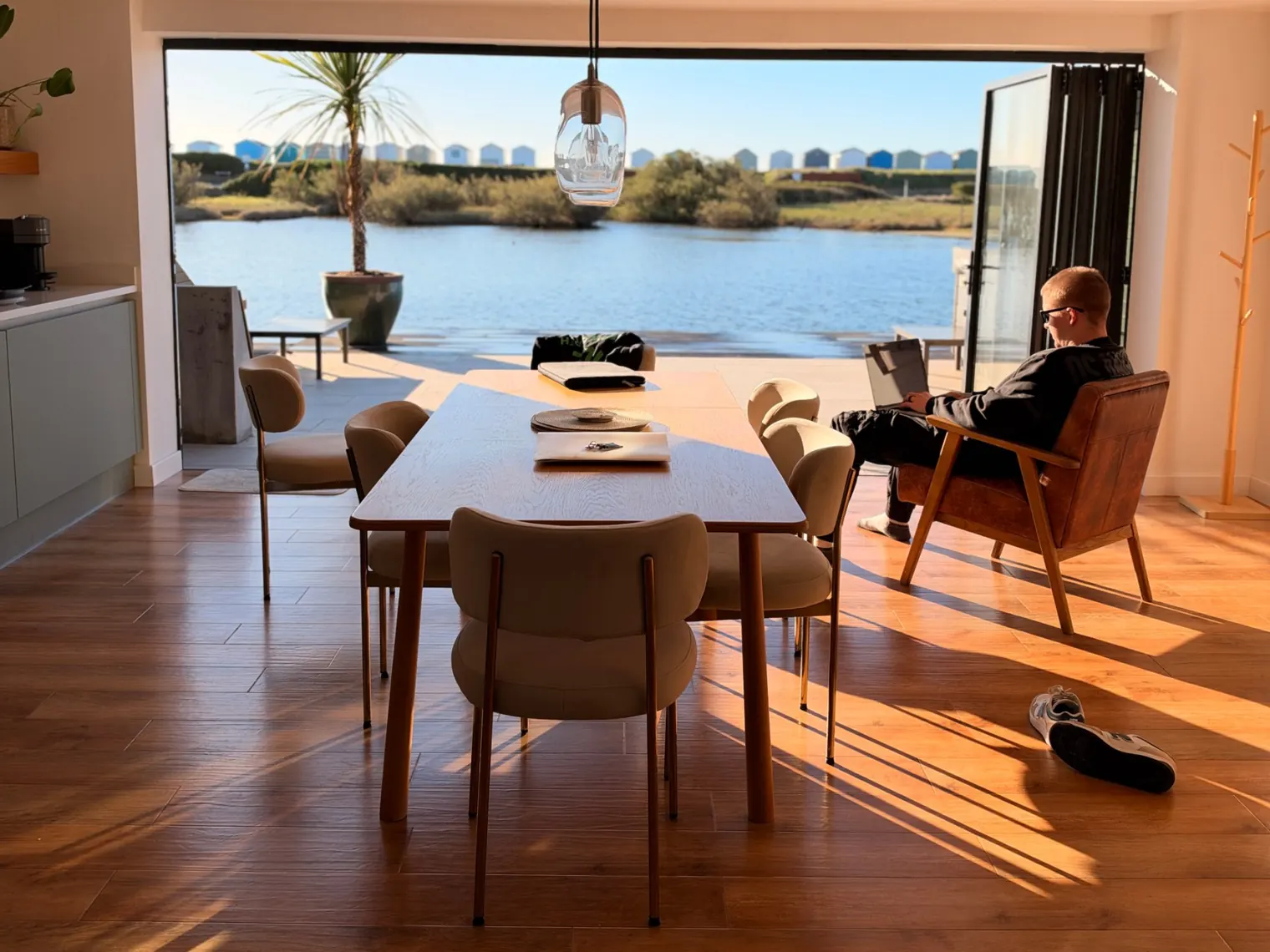 Open-plan living room of the Search Theory team Airbnb with bi-fold doors open onto the water